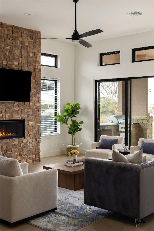 116 Azalea Loop, Horseshoe Bay, TX 78657 - living room with a ceiling fan, a fireplace, baseboards, and wood finished floors