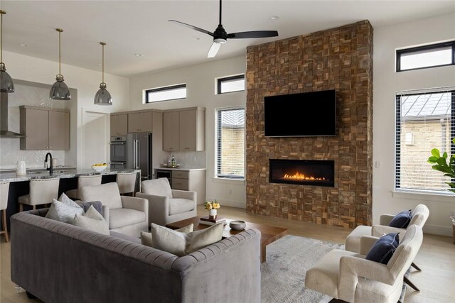 116 Azalea Loop, Horseshoe Bay, TX 78657 - living room featuring light wood-style flooring, a large fireplace, a high ceiling, and a ceiling fan