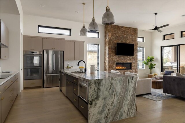 116 Azalea Loop, Horseshoe Bay, TX 78657 - kitchen with appliances with stainless steel finishes, open floor plan, a sink, gray cabinets, and a high ceiling