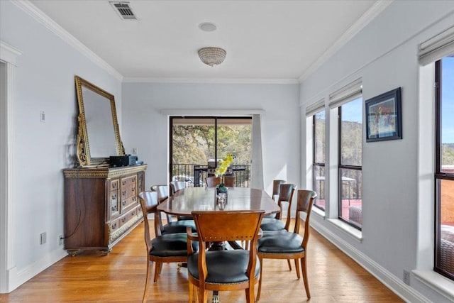 dining area featuring crown molding, visible vents, and light wood-style floors