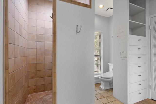 full bath featuring tiled shower, toilet, and tile patterned floors