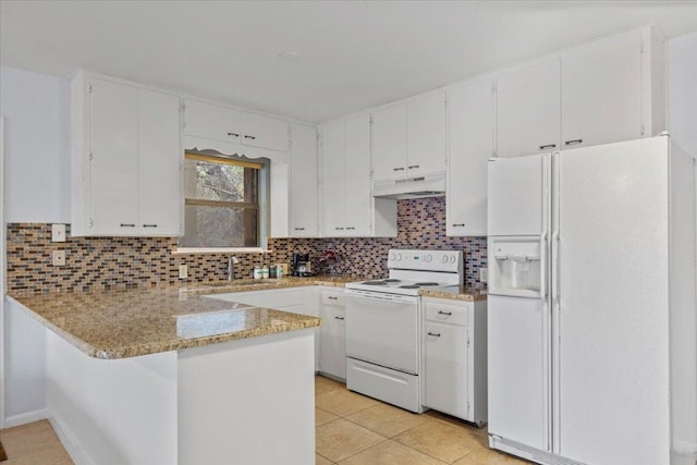 kitchen with a peninsula, white appliances, backsplash, and under cabinet range hood