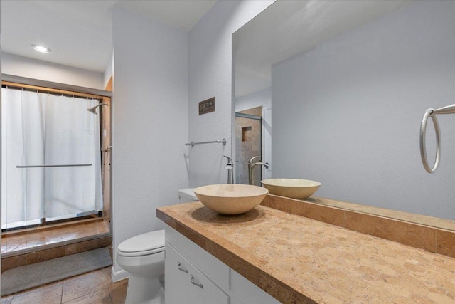 bathroom featuring toilet, a shower with shower curtain, tile patterned flooring, and vanity