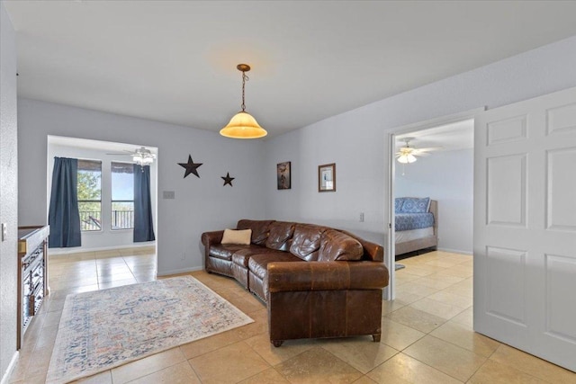 living room with ceiling fan, baseboards, and light tile patterned flooring