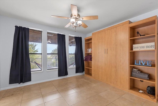 unfurnished bedroom featuring light tile patterned floors, ceiling fan, and baseboards