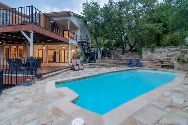 outdoor pool featuring a patio, a deck, and stairs