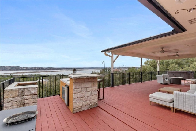 wooden deck with a water view and ceiling fan