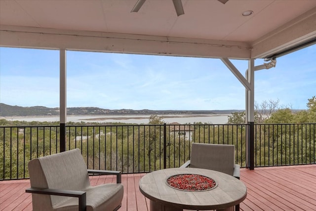 deck featuring ceiling fan and a fire pit