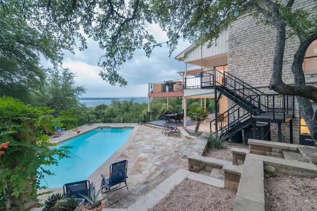 view of swimming pool with a fenced in pool, a patio, stairway, a water view, and central AC