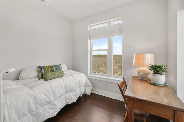 bedroom featuring visible vents, baseboards, and wood finished floors