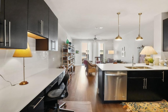 kitchen with light countertops, stainless steel dishwasher, a sink, and dark cabinetry