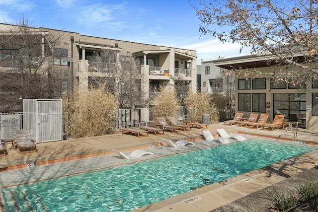 pool with a patio area, fence, and central AC unit