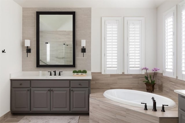 full bathroom with a garden tub, a shower stall, and vanity