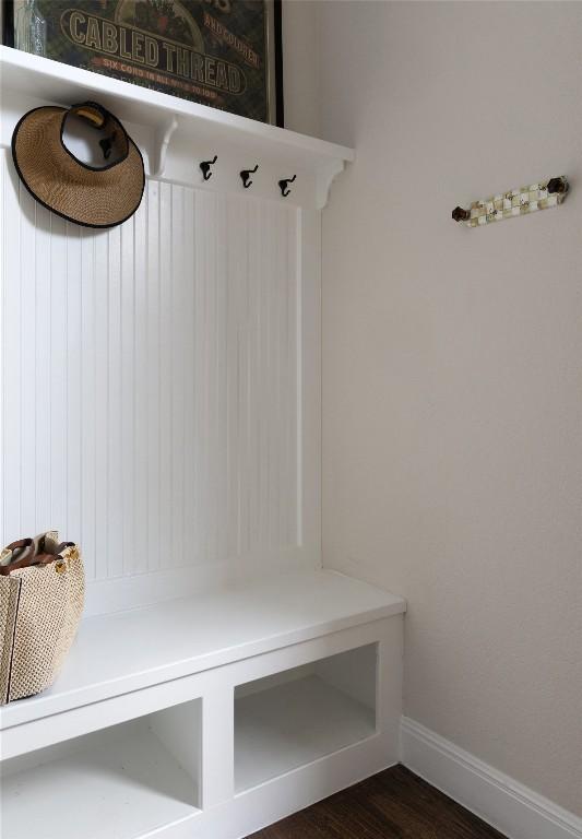 mudroom with baseboards and dark wood-type flooring