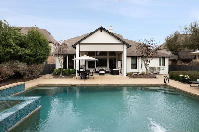 rear view of property featuring fence, an outdoor living space, a fenced in pool, and a patio