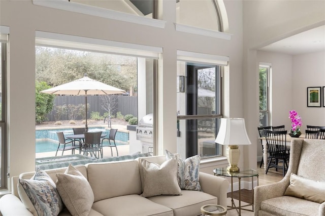 living area featuring a high ceiling, baseboards, and wood finished floors