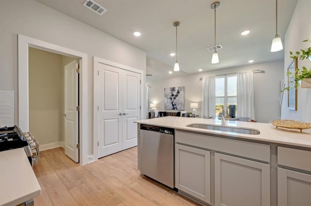 kitchen with light wood finished floors, appliances with stainless steel finishes, a sink, and visible vents