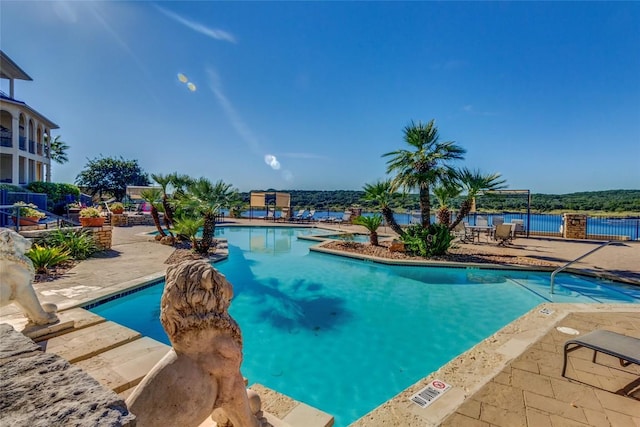 pool with a patio area and fence