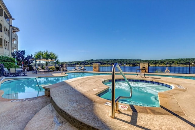 community pool featuring a hot tub, fence, and a patio