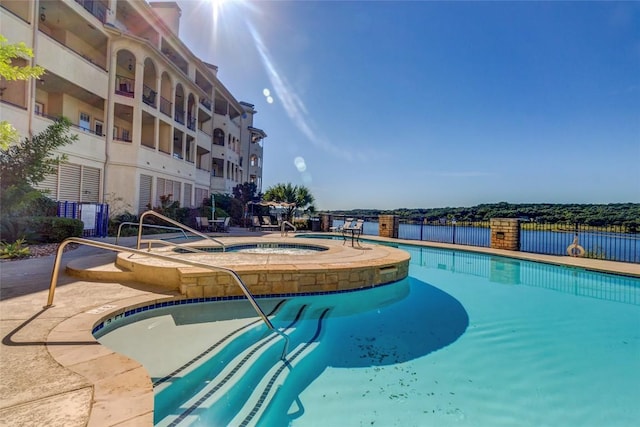 view of pool featuring a hot tub and fence