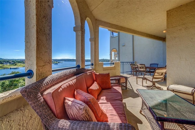 balcony with outdoor lounge area and a water view