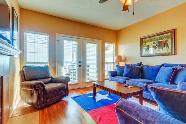 3404 American Dr Unit 3211, Lago Vista, TX 78645 - living area with french doors, ceiling fan, light wood-style floors, a textured ceiling, and a fireplace