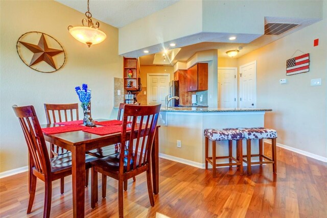 dining area with light wood finished floors, baseboards, visible vents, and recessed lighting