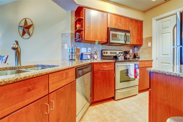 3404 American Dr Unit 3211, Lago Vista, TX 78645 - kitchen with stainless steel appliances, tasteful backsplash, light stone countertops, and brown cabinetry