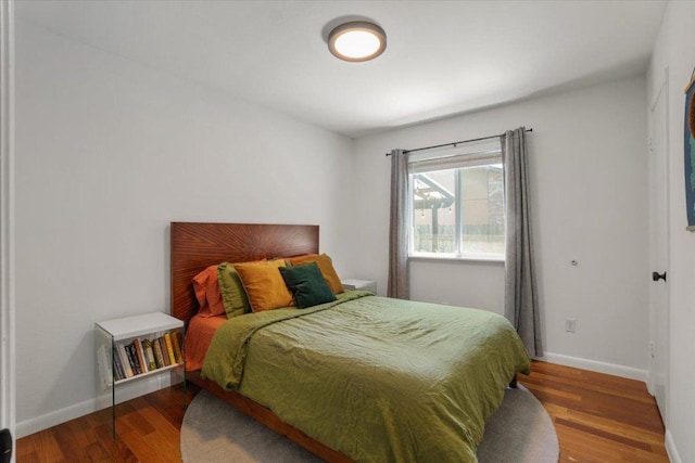 bedroom featuring baseboards and wood finished floors