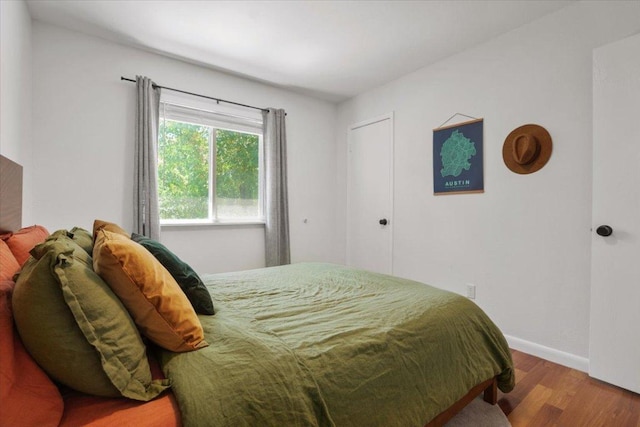 bedroom with wood finished floors and baseboards