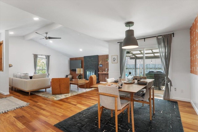 dining space featuring a ceiling fan, lofted ceiling with beams, baseboards, and wood finished floors