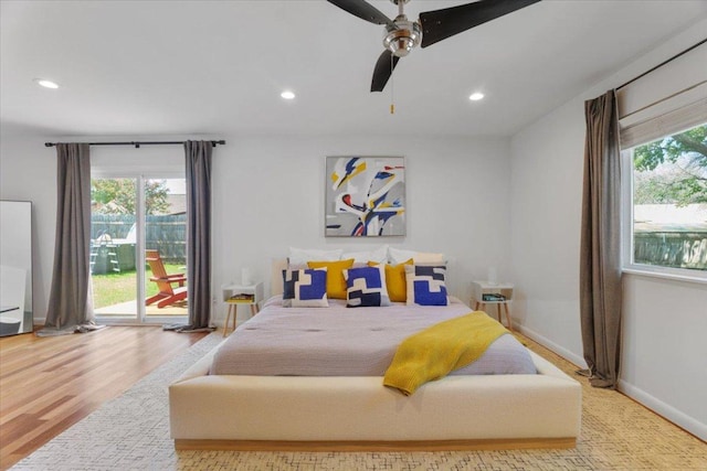 bedroom featuring multiple windows, recessed lighting, wood finished floors, and access to exterior