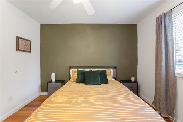 bedroom featuring ceiling fan, baseboards, and wood finished floors