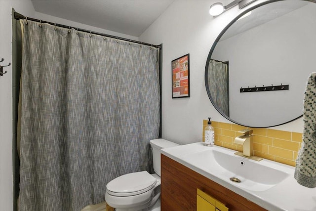 bathroom featuring tasteful backsplash, vanity, and toilet