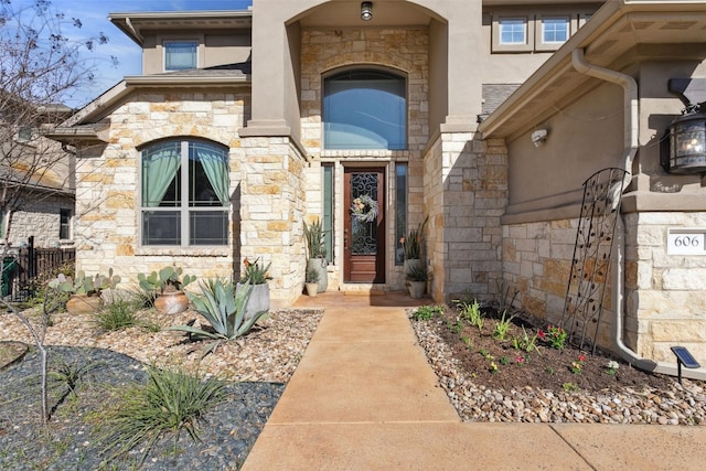 view of exterior entry with stone siding and stucco siding