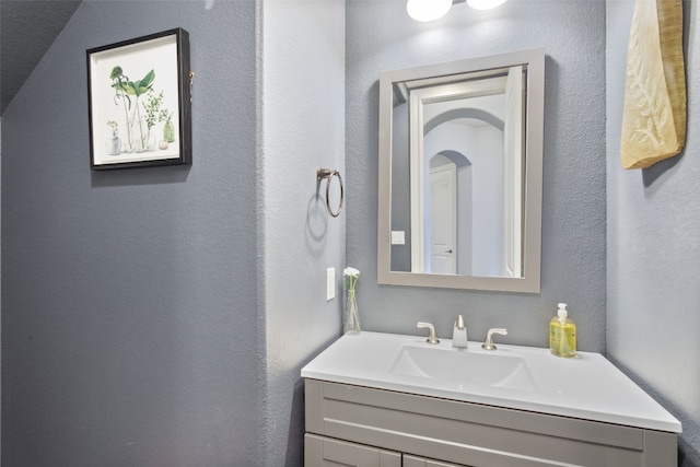 bathroom featuring vanity and a textured wall