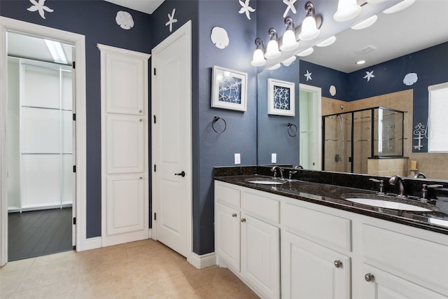 606 Anfield Cir, Austin, TX 78738 - bathroom featuring a shower stall, tile patterned floors, double vanity, and a closet