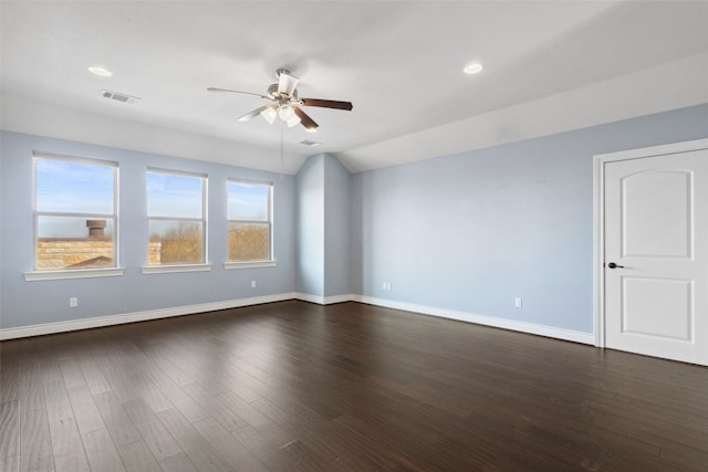 unfurnished room featuring baseboards, visible vents, dark wood finished floors, ceiling fan, and vaulted ceiling