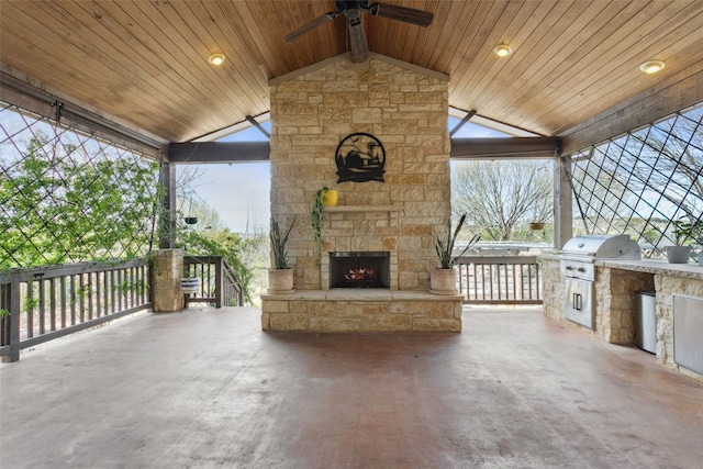 view of patio / terrace featuring area for grilling, an outdoor stone fireplace, exterior kitchen, and a ceiling fan