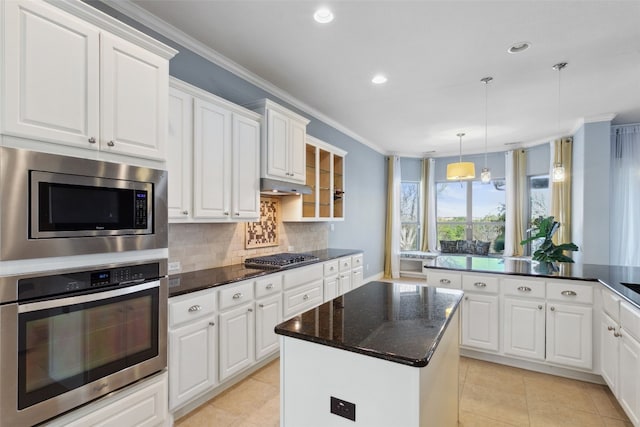 606 Anfield Cir, Austin, TX 78738 - kitchen with appliances with stainless steel finishes, ornamental molding, decorative backsplash, a center island, and white cabinetry