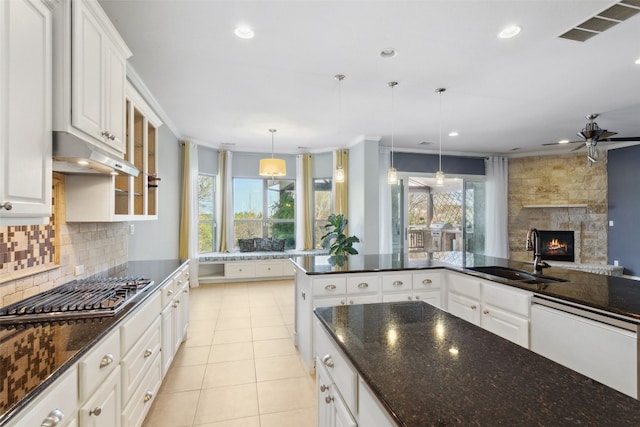 kitchen featuring visible vents, a sink, under cabinet range hood, stainless steel gas stovetop, and white dishwasher