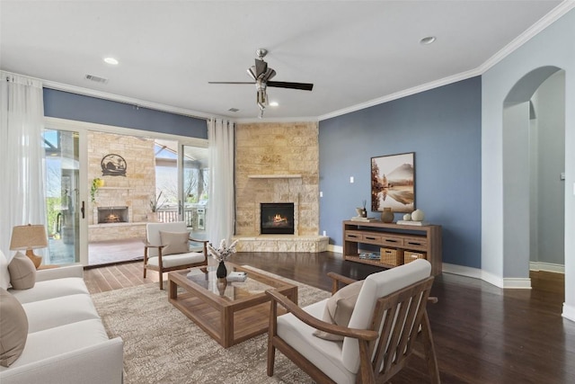 606 Anfield Cir, Austin, TX 78738 - living area with a fireplace, arched walkways, crown molding, a ceiling fan, and wood finished floors
