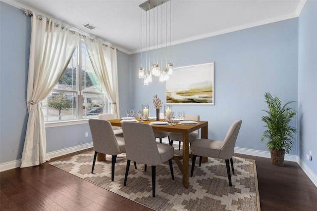 dining room featuring ornamental molding, baseboards, and wood finished floors