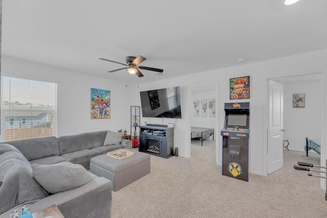 living room featuring a ceiling fan, light colored carpet, and baseboards