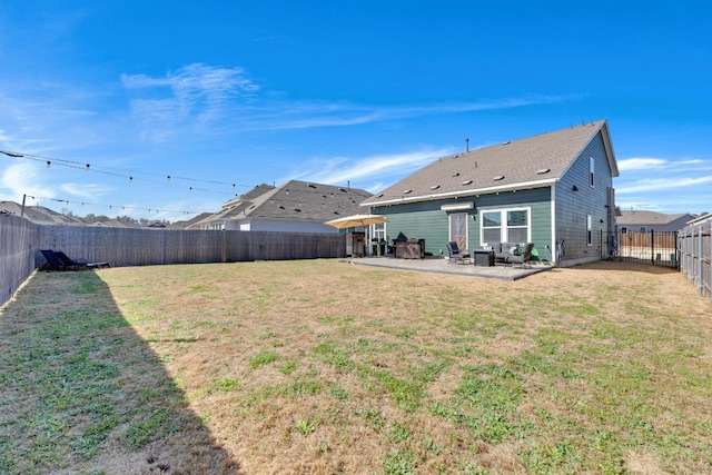 rear view of property with a fenced backyard, a lawn, and a patio