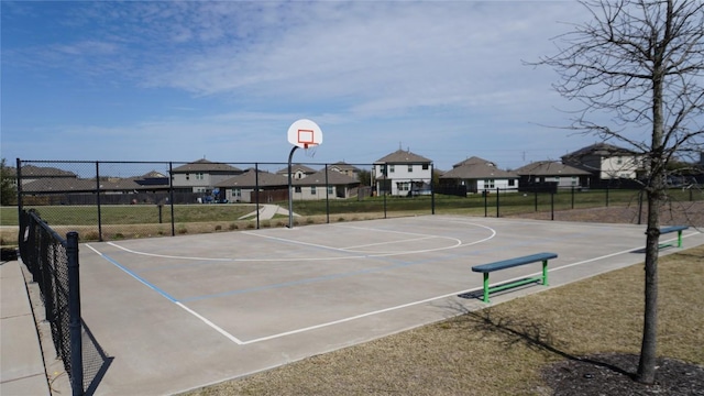 view of basketball court with community basketball court, a residential view, and fence