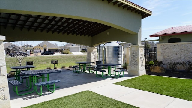 view of property's community with a yard, a patio, and a gate