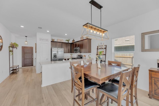 dining area with light wood-style floors, visible vents, and recessed lighting