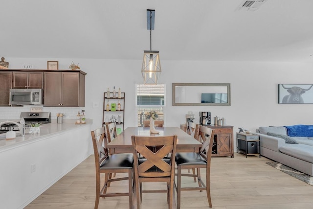 dining room featuring light wood-type flooring and visible vents