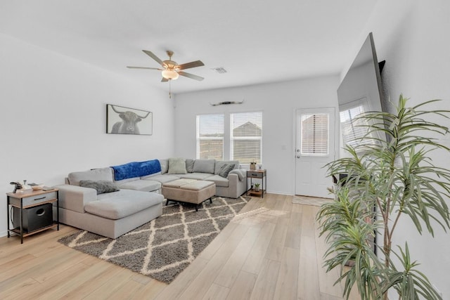 living area with light wood-style floors, visible vents, and a ceiling fan